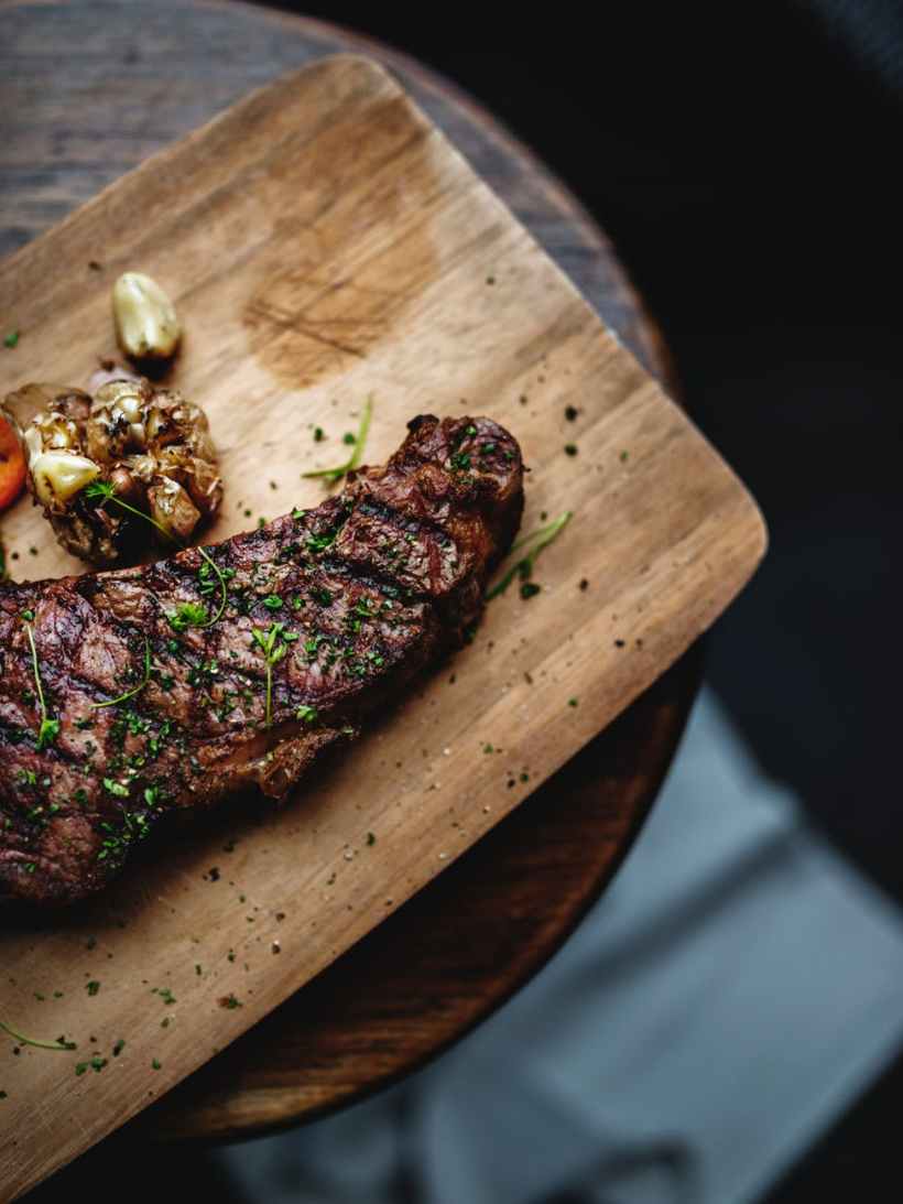 cooked meat on brown chopping board