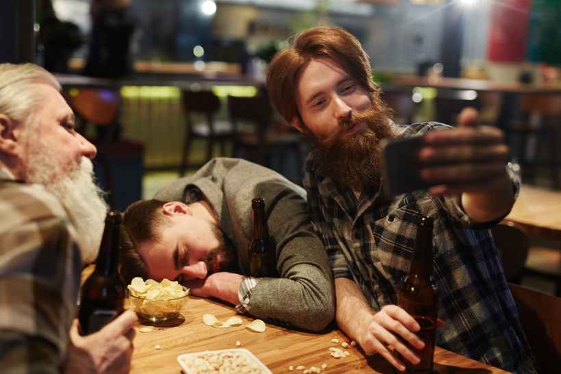 man taking a selfie with a drunk man
