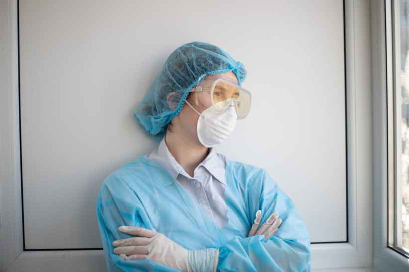 woman in blue scrub suit wearing white mask